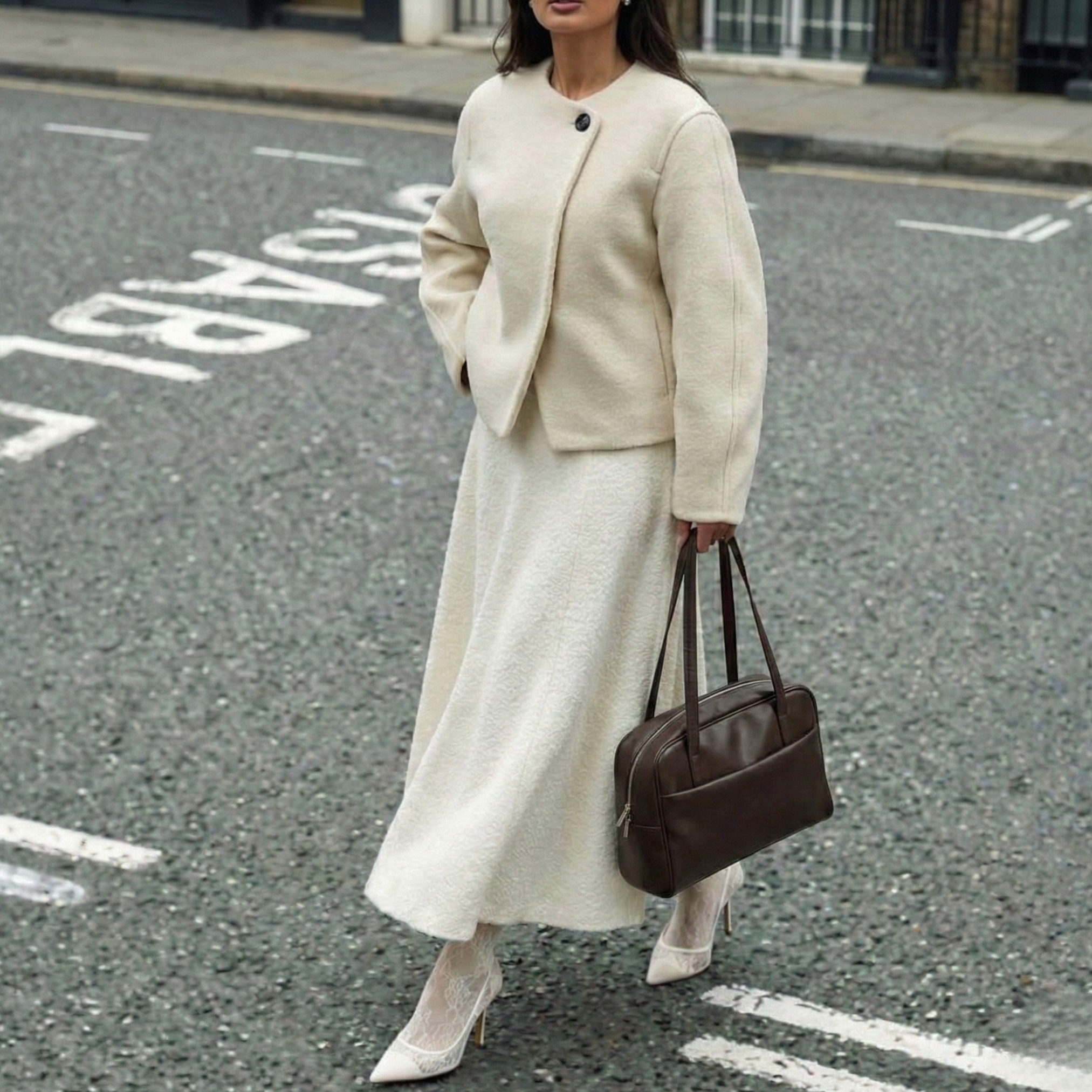 Woman in a beige suit with a brown bag on a street